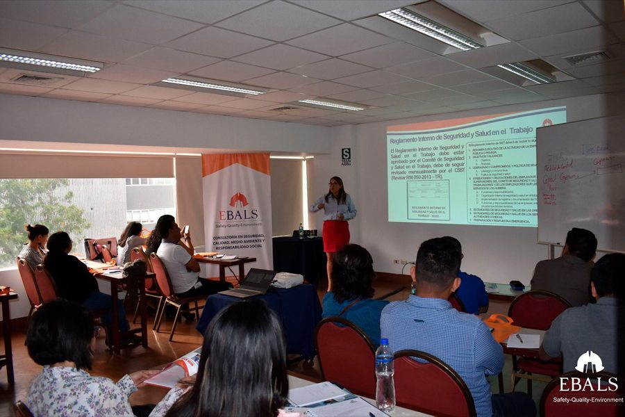 Sesión de capacitación en aula con contenido de seguridad y salud proyectado